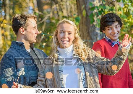 Picture - Portrait of young woman with teenage and older brother in woods. Fotosearch