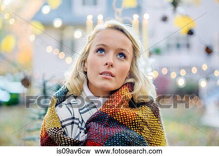 Portrait of young woman wrapped in blanket in front of xmas lights View Large Photo Image Stock Photo - Portrait of young woman wrapped in blanket in front of xmas lights. Fotosearch