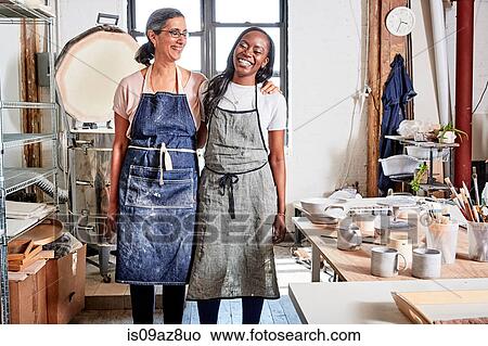 Potters in workshop wearing aprons smiling View Large Photo Image Picture - Potters in workshop wearing aprons smiling. Fotosearch