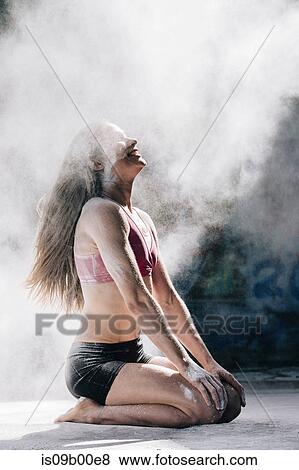 Powder covered woman kneeling smiling in cloud of dust View Large Photo Image Stock Photo - Powder covered woman kneeling smiling in cloud of dust. Fotosearch