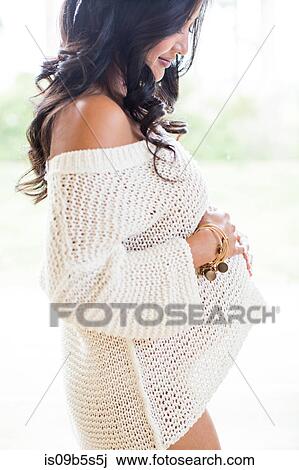 Pregnant woman holding stomach, smiling View Large Photo Image Stock Image - Pregnant woman holding stomach, smiling. Fotosearch
