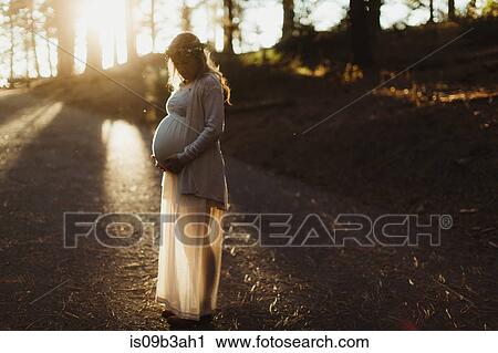Pregnant woman in sunlight touching stomach View Large Photo Image Stock Image - Pregnant woman in sunlight touching stomach. Fotosearch