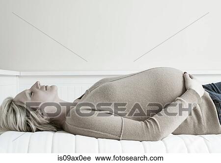 Pregnant woman relaxing on sofa View Large Photo Image Stock Image - Pregnant woman relaxing on sofa. Fotosearch