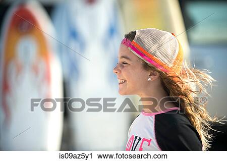 Stock Image - Profile of young girl at beach, smiling. Fotosearch