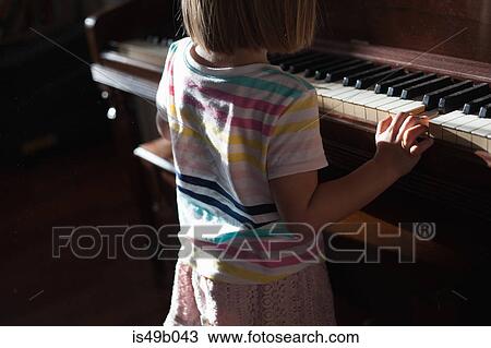 Rear mid section view of girl standing playing old piano at home View Large Photo Image Stock Image - Rear mid section view of girl standing playing old piano at home. Fotosearch