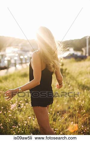 Rear view of blonde women wearing playsuit on grass in sunlight View Large Photo Image Stock Image - Rear view of blonde women wearing playsuit on grass in sunlight. Fotosearch
