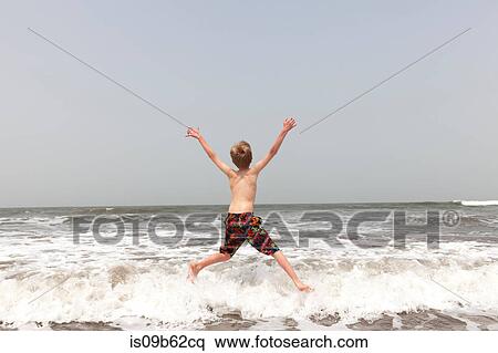 Rear view of boy jumping in sea, Goa, India, Asia View Large Photo Image Stock Photography - Rear view of boy jumping in sea, Goa, India, Asia. Fotosearch