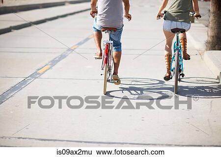 Rear view of couple cycling at Venice Beach, Los Angeles, California, USA View Large Photo Image Stock Photograph - Rear view of couple cycling at Venice Beach, Los Angeles, California, USA. Fotosearch