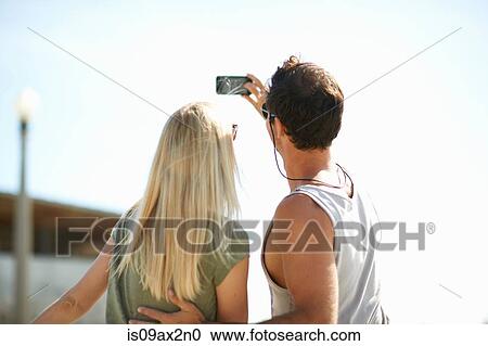 Rear view of couple taking smartphone selfie at Venice Beach, Los Angeles, California, USA View Large Photo Image Stock Image - Rear view of couple taking smartphone selfie at Venice Beach, Los Angeles, California, USA. Fotosearch