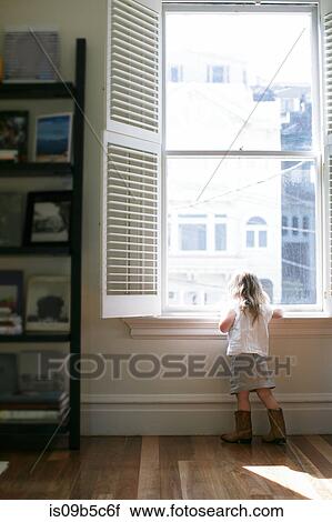 Rear view of female toddler looking through apartment window View Large Photo Image Stock Image - Rear view of female toddler looking through apartment window. Fotosearch