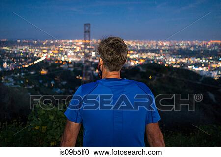 Stock Image - Rear view of jogger looking away at view, Runyon Canyon, Los Angeles, California, USA. Fotosearch