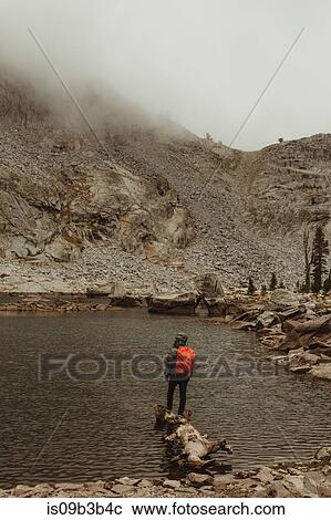 Stock Image - Rear view of male hiker looking out from lake, Mineral King, Sequoia National Park, California, USA. Fotosearch