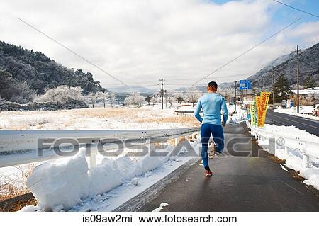 Rear view of mature male runner running on road in winter, Lake Kawaguchiko, Mount Fuji, Japan View Large Photo Image Stock Image - Rear view of mature male runner running on road in winter, Lake Kawaguchiko, Mount Fuji, Japan. Fotosearch