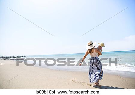 Rear view of mother carrying baby son on beach, Malibu, California, USA View Large Photo Image Stock Image - Rear view of mother carrying baby son on beach, Malibu, California, USA. Fotosearch