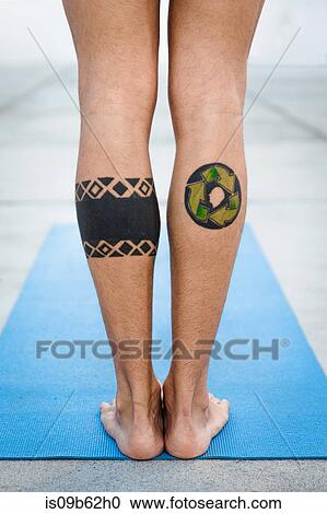 Rear view of tattooed legs of man practicing yoga, standing on yoga mat View Large Photo Image Stock Image - Rear view of tattooed legs of man practicing yoga, standing on yoga mat. Fotosearch