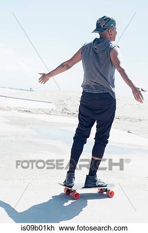 Rear view of woman on skateboard View Large Photo Image Stock Image - Rear view of woman on skateboard. Fotosearch
