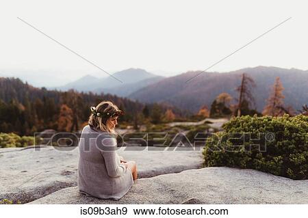 Rear view of woman sitting on rocks in mountains, Sequoia national park, California, USA View Large Photo Image Stock Photo - Rear view of woman sitting on rocks in mountains, Sequoia national park, California, USA. Fotosearch