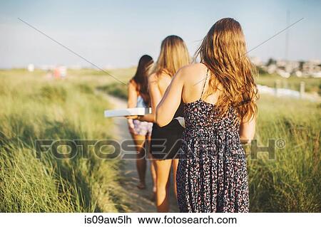 Rear view of women carrying pizza boxes on coastal path View Large Photo Image Stock Image - Rear view of women carrying pizza boxes on coastal path. Fotosearch