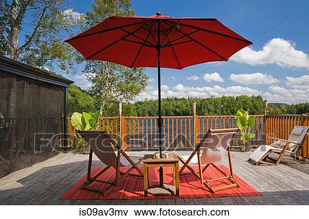 Red parasol and wooden folding canvas chairs on grey vertical plank wooden deck in backyard View Large Photo Image Stock Photo - Red parasol and wooden folding canvas chairs on grey vertical plank wooden deck in backyard. Fotosearch