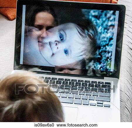 Reflection of mother looking at photographs of daughter on laptop View Large Photo Image Stock Image - Reflection of mother looking at photographs of daughter on laptop. Fotosearch