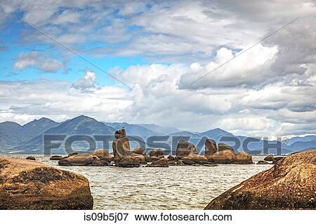 Rocks in sea by mountains, Florianopolis, Santa Catarina, Brazil View Large Photo Image Stock Photo - Rocks in sea by mountains, Florianopolis, Santa Catarina, Brazil. Fotosearch