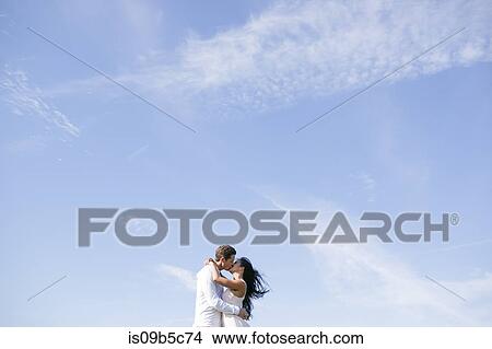 Romantic couple kissing against vast blue sky View Large Photo Image Picture - Romantic couple kissing against vast blue sky. Fotosearch