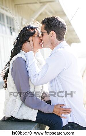 Romantic couple kissing by chalets View Large Photo Image Stock Image - Romantic couple kissing by chalets. Fotosearch