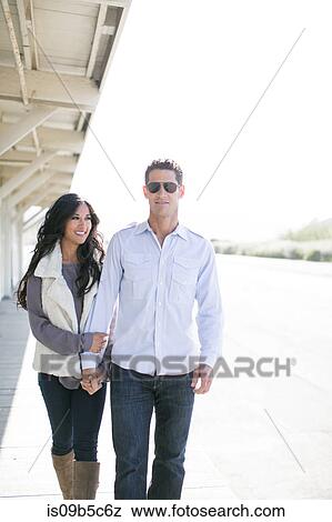 Romantic couple strolling hand in hand by chalets View Large Photo Image Stock Photo - Romantic couple strolling hand in hand by chalets. Fotosearch
