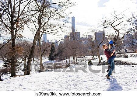 Stock Image - Romantic young couple having fun in snowy Central Park, New York, USA. Fotosearch