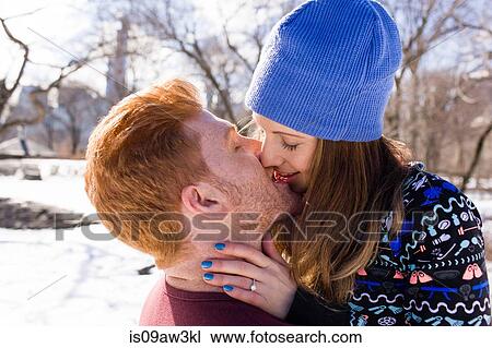 Stock Image - Romantic young couple kissing in snowy Central Park, New York, USA. Fotosearch
