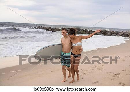 Romantic young surfing couple strolling on Rockaway Beach, New York State, USA View Large Photo Image Stock Photography - Romantic young surfing couple strolling on Rockaway Beach, New York State, USA. Fotosearch