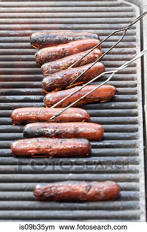 Row of sausages barbecuing on grill View Large Photo Image Picture - Row of sausages barbecuing on grill. Fotosearch