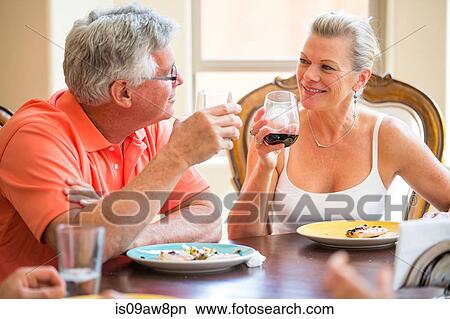 Senior couple chatting at dining table View Large Photo Image Picture - Senior couple chatting at dining table. Fotosearch