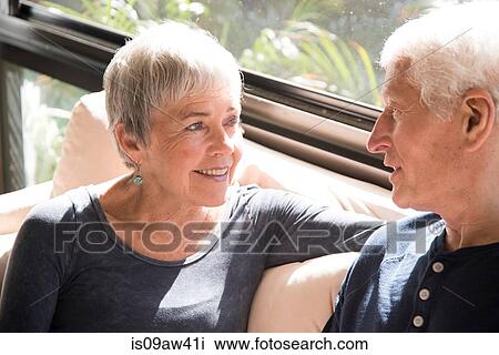 Stock Image - Senior couple, relaxing, sitting face to face. Fotosearch