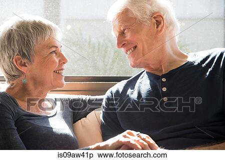 Senior couple sitting together, face to face, smiling View Large Photo Image Stock Photography - Senior couple sitting together, face to face, smiling. Fotosearch