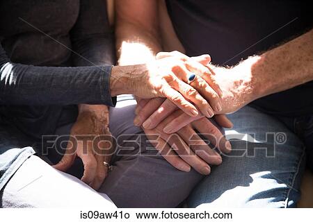Senior couple sitting together, touching hands, mid section, close-up View Large Photo Image Picture - Senior couple sitting together, touching hands, mid section, close-up. Fotosearch