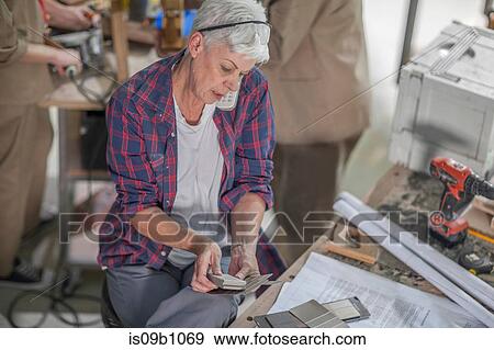 Senior female carpenter looking at swatches in furniture making workshop View Large Photo Image Stock Photo - Senior female carpenter looking at swatches in furniture making workshop. Fotosearch