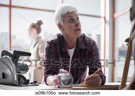 Senior female carpenter making notes in furniture making workshop View Large Photo Image Picture - Senior female carpenter making notes in furniture making workshop. Fotosearch