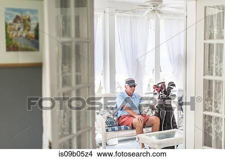 Senior male golfer sitting through conservatory doorway with golf bag View Large Photo Image Picture - Senior male golfer sitting through conservatory doorway with golf bag. Fotosearch
