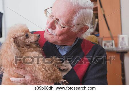 Senior man carrying pet dog at home View Large Photo Image Stock Image - Senior man carrying pet dog at home. Fotosearch