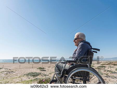 Senior man in wheelchair looking out from dunes, Playa del Ray, California, USA View Large Photo Image Stock Image - Senior man in wheelchair looking out from dunes, Playa del Ray, California, USA. Fotosearch