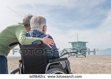 Senior man in wheelchair with wife looking out from beach, Santa Monica, California, USA View Large Photo Image Stock Photo - Senior man in wheelchair with wife looking out from beach, Santa Monica, California, USA. Fotosearch