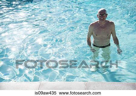 Senior man standing in outdoor swimming pool, smiling View Large Photo Image Stock Photography - Senior man standing in outdoor swimming pool, smiling. Fotosearch