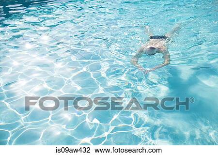 Stock Image - Senior man swimming in outdoor swimming pool. Fotosearch