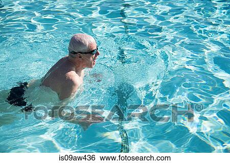 Stock Photograph - Senior man swimming in outdoor swimming pool. Fotosearch