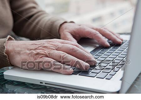 Stock Photography - Senior man using laptop at home. Fotosearch