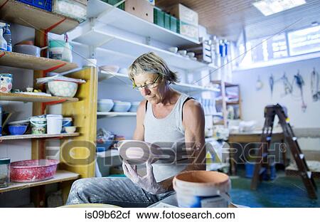 Senior woman in pottery workshop, inspecting bowl View Large Photo Image Stock Image - Senior woman in pottery workshop, inspecting bowl. Fotosearch