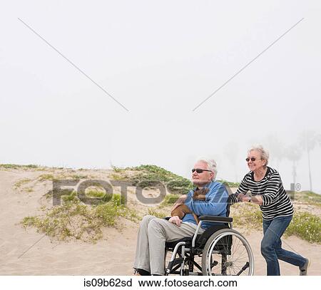 Senior woman pushing husband in wheelchair on dunes, Playa del Ray, California, USA View Large Photo Image Stock Image - Senior woman pushing husband in wheelchair on dunes, Playa del Ray, California, USA. Fotosearch