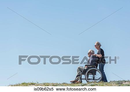 Senior woman pushing husband in wheelchair on dunes, Playa del Ray, California, USA View Large Photo Image Stock Photography - Senior woman pushing husband in wheelchair on dunes, Playa del Ray, California, USA. Fotosearch