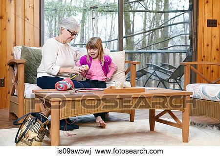 Senior woman showing granddaughter how to knit on living room sofa View Large Photo Image Stock Image - Senior woman showing granddaughter how to knit on living room sofa. Fotosearch